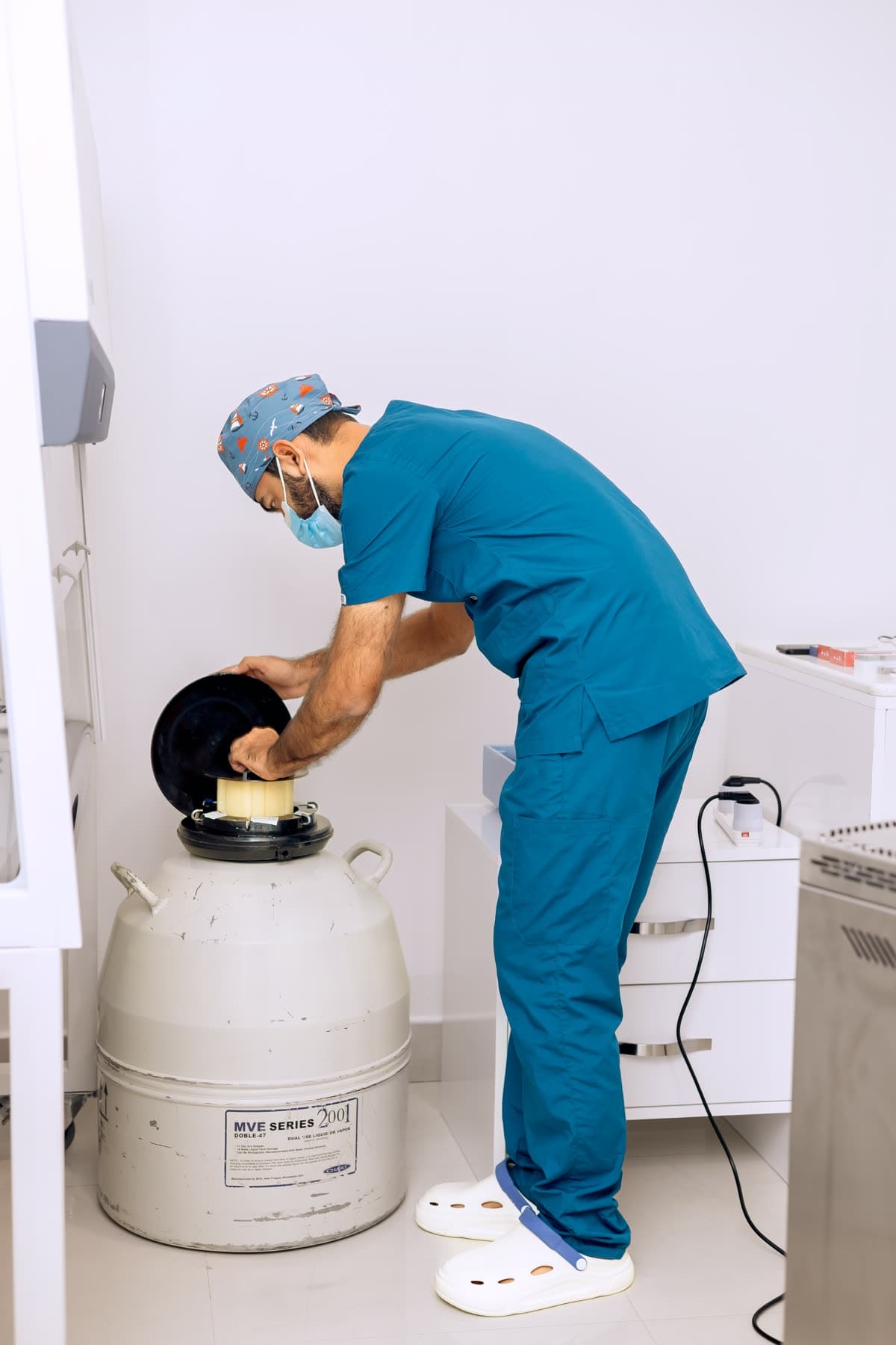 Embryologist retrieving a cane from a cryogenic storage tank at Hope IVF International
