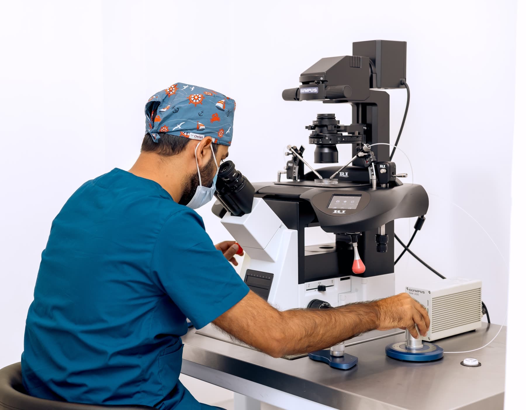 Embryologist working at the micromanipulation microscope in the Hope IVF International laboratory